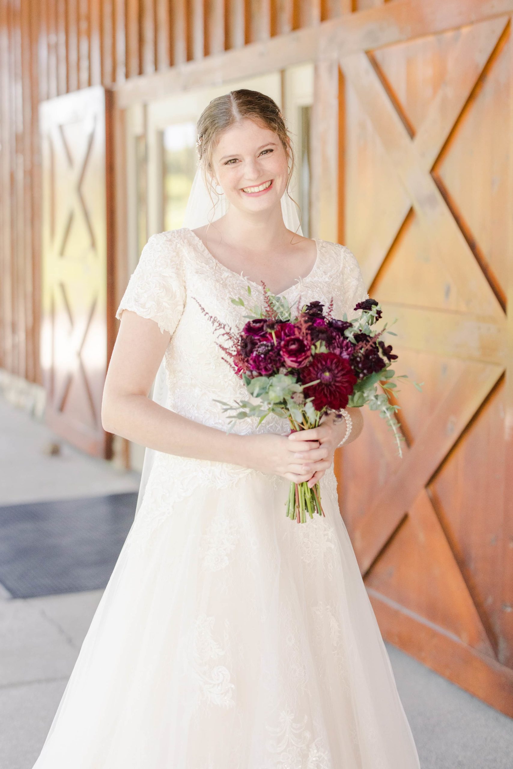 bride smiling at the camera holding her bouquet