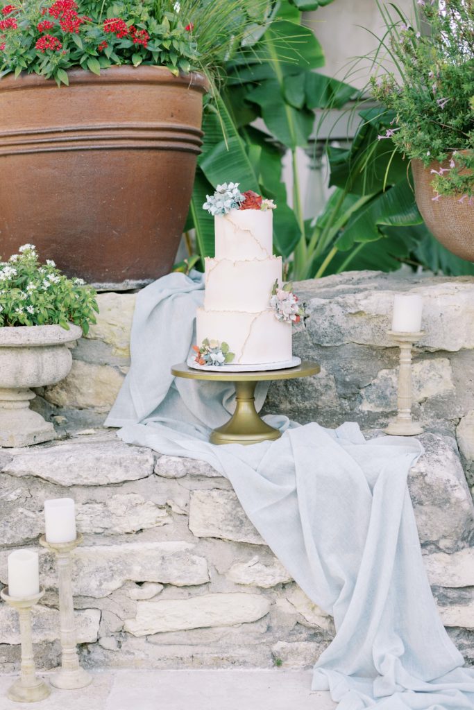 Wedding cake sitting on a stone wall