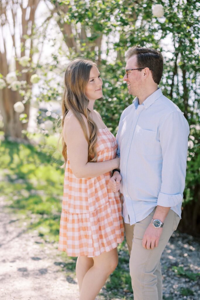 couple smiling at each other at their dallas arboretum session