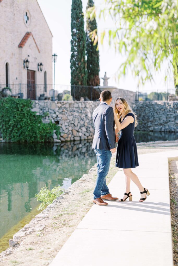 Emily+Michaellaughing at the camera during their Adriatica Village Engagement session
