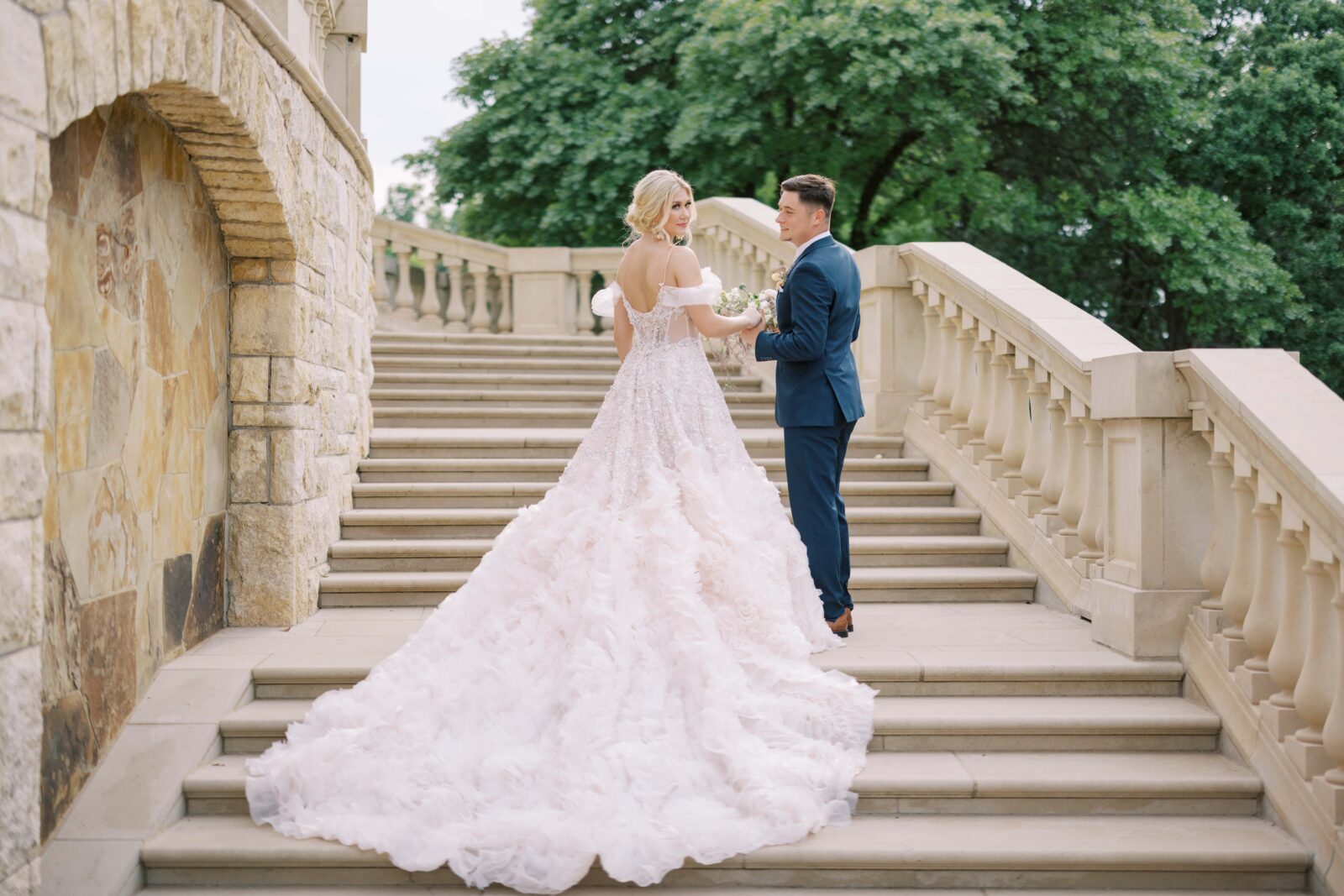 bride and groom on the steps of the olana backyard holfing hands