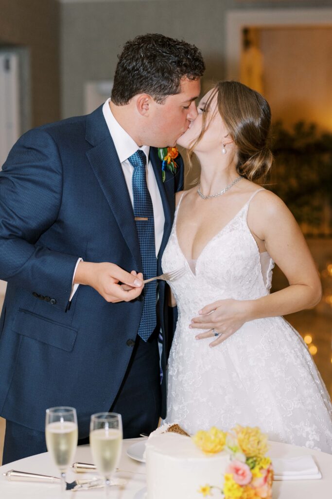 bride and groom kissing after eating cake at the rosewood mansion 