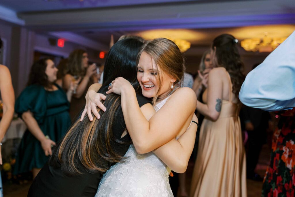bride hugging a friend during the reception at the rosewood mansion 