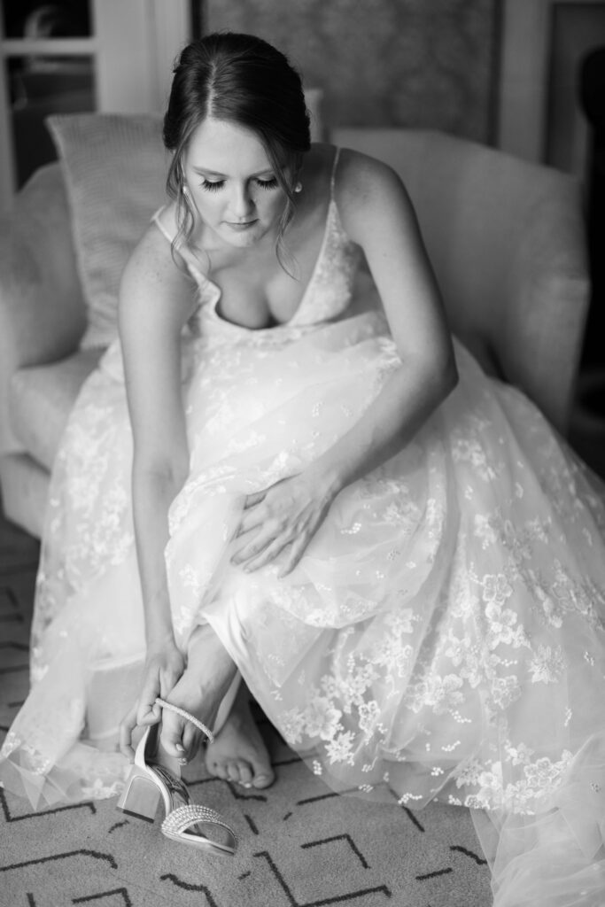 bride putting on her shoes in her rosewood mansion hotel room