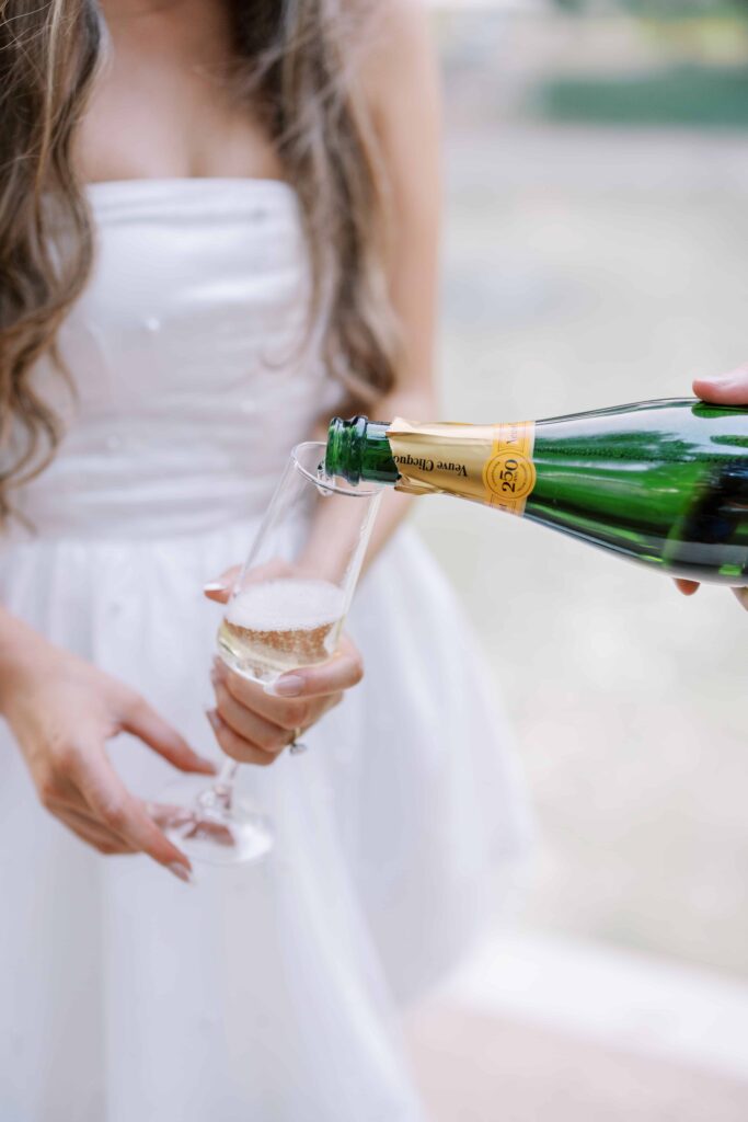 groom pouring champagne to celebrate their flippen park engagement photos