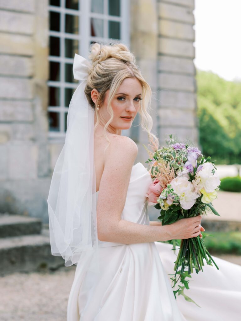 bride holding her bouquet looking at the camera at  her france wedding