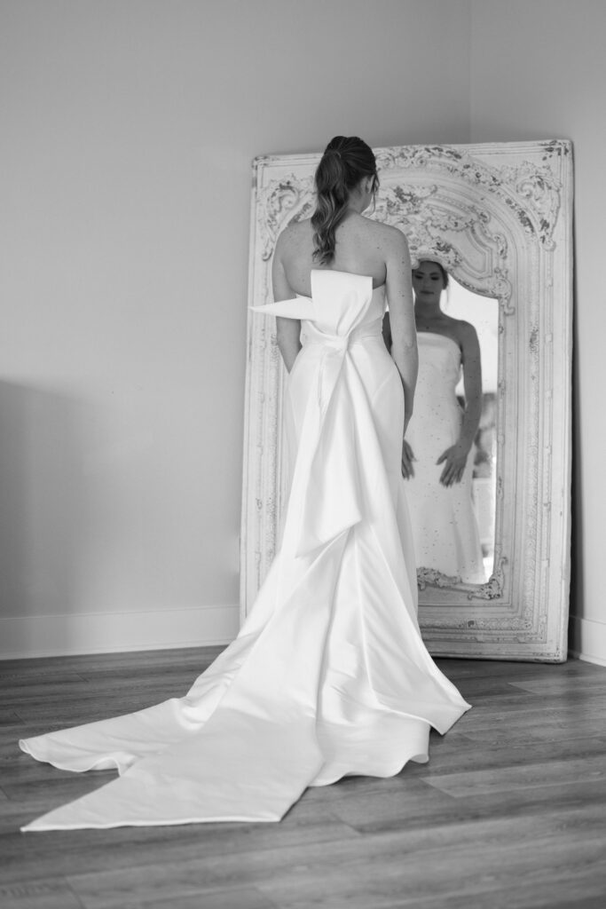 bride looking in the mirror in the brida suite at her Davis and Grey Farms Bridal session 