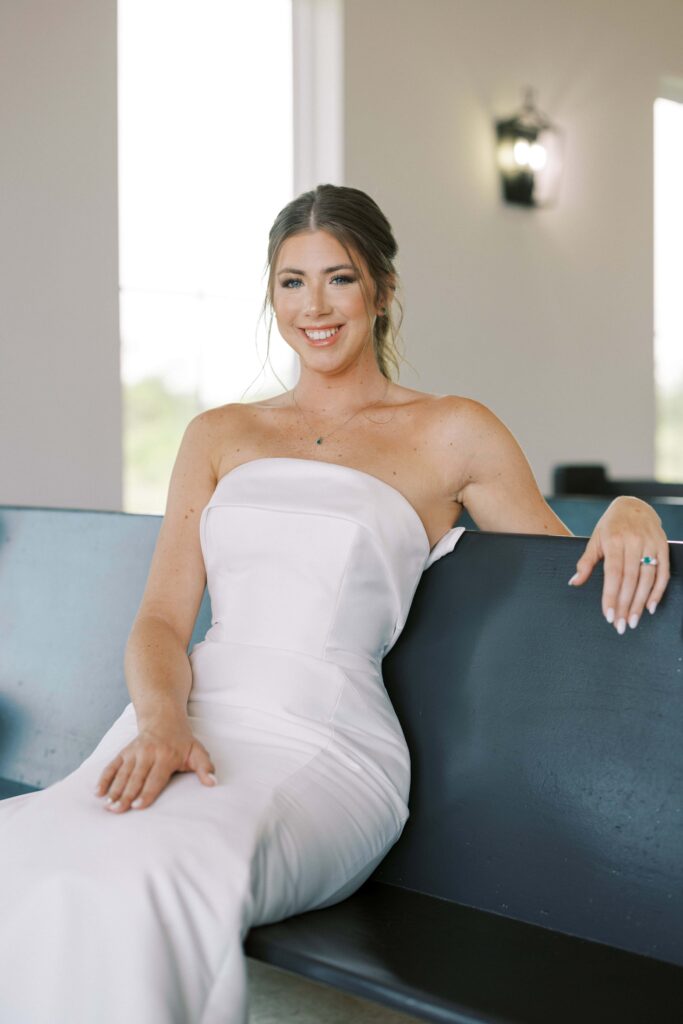 Bride sitting on a pew inside of the chapel for her Davis and Grey Farms Bridal session 