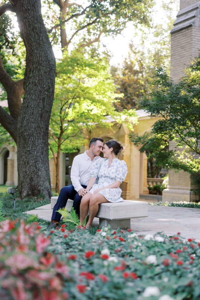 sam and spencer looking at each other sitting on the bench during their Engagement Session at HPUMC in Dallas