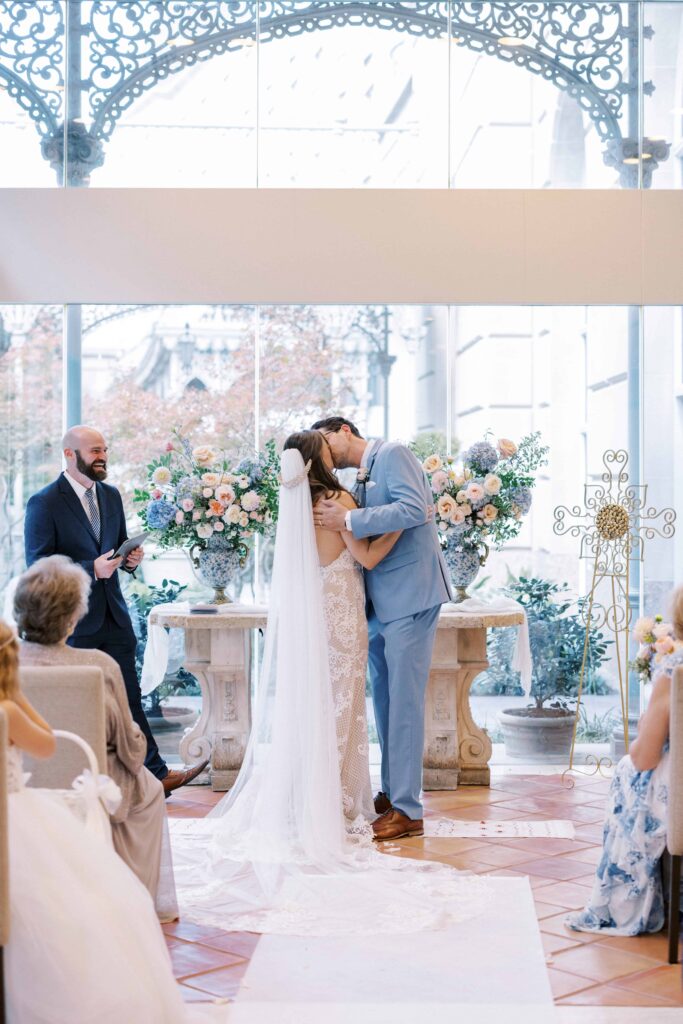 bride and groom kissing at the altar during their Hotel Crescent Court wedding