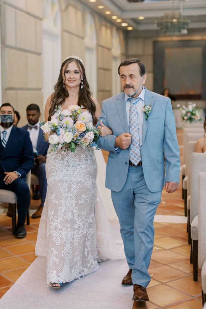 bride walking down the aisle with her dad during her Hotel Crescent Court wedding