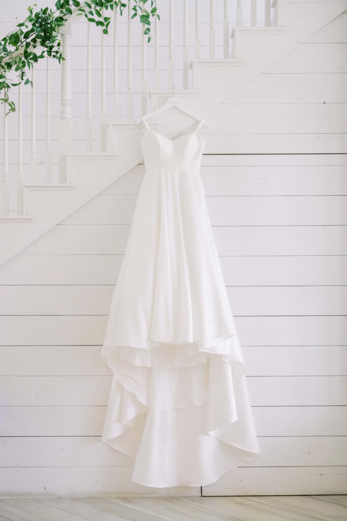 wedding gown hanging from the staircase at The Nest at Ruth Farms