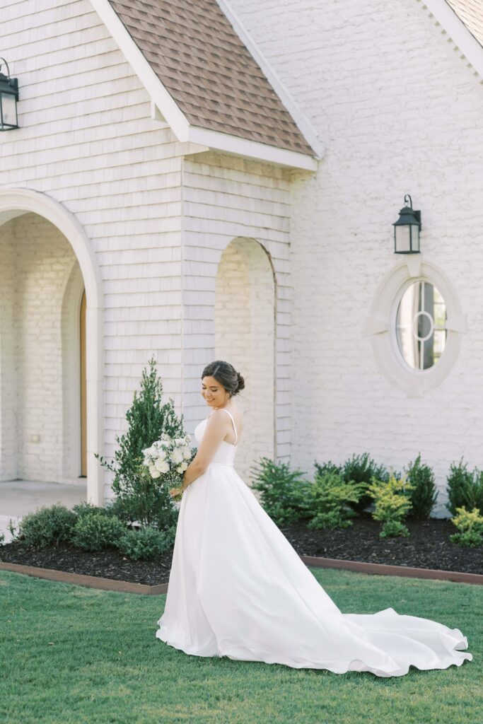 Bride standing in front of the chapel at The Nest at Ruth Farms with her bouquet 