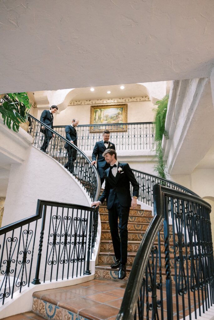 groom and his groomsmen walking down the stairs at this Intimate Wedding at Villa Antonia near Austin