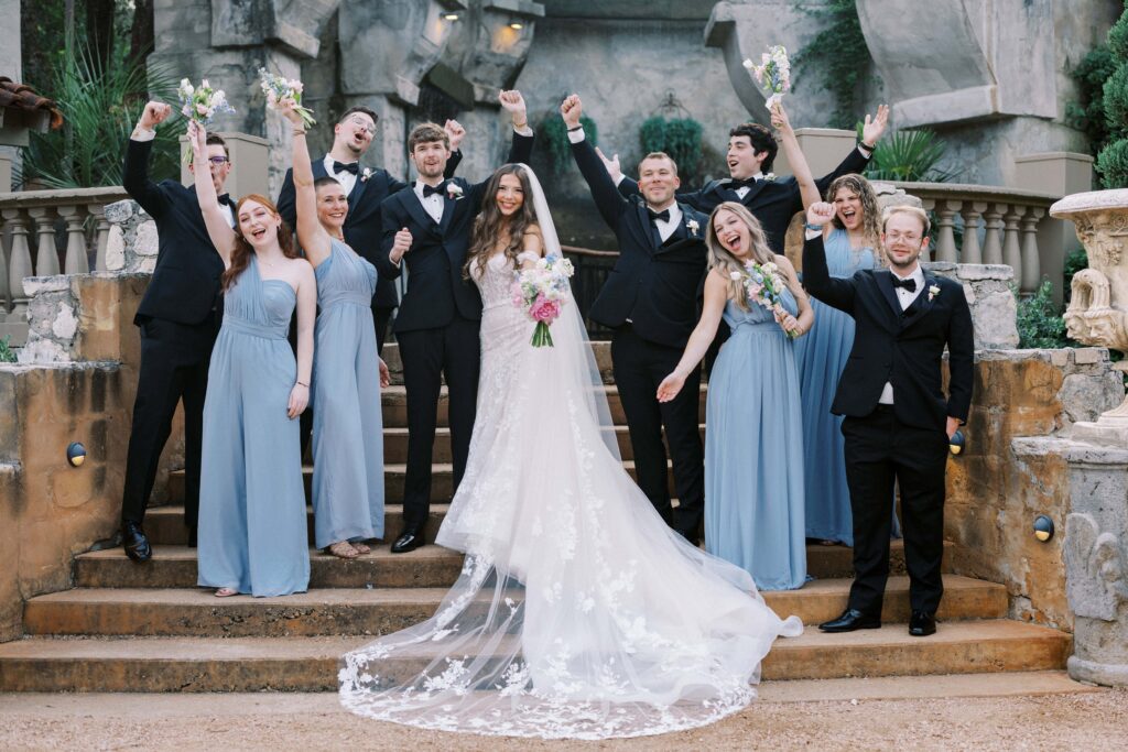 bridal party standing on the stairs shouting to celebrate the newlyweds at this Intimate Wedding at Villa Antonia near Austin