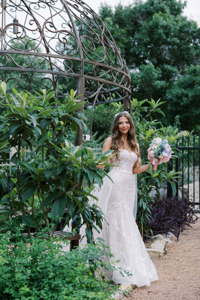 bride under the gazebo holding her bouquet at her Intimate Wedding at Villa Antonia near Austin