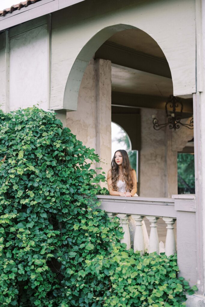 bride leaning against the balcony looking away at her Intimate Wedding at Villa Antonia near Austin