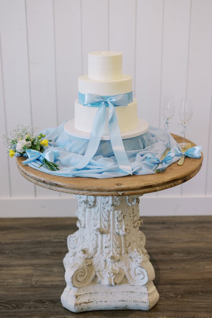 white cake with blue ribbon for the Wedding at Chandelier Farms