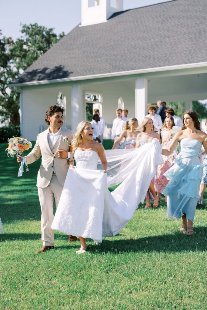 bridal party colorfully dressed walking away from the chapel for the Wedding at Chandelier Farms