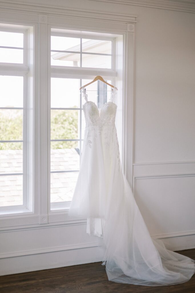 wedding gown hanging off the window at The Springs Event Venue Weatherford