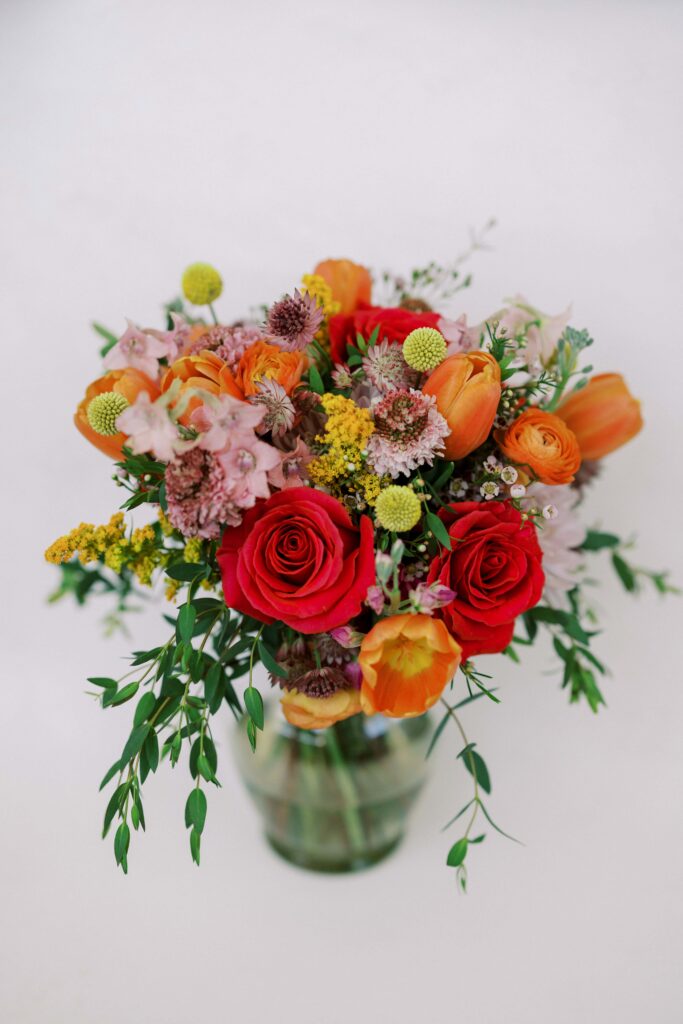 bridal bouquet with red, pink, orange, yellow flowers for her wedding at The Springs Event Venue Weatherford