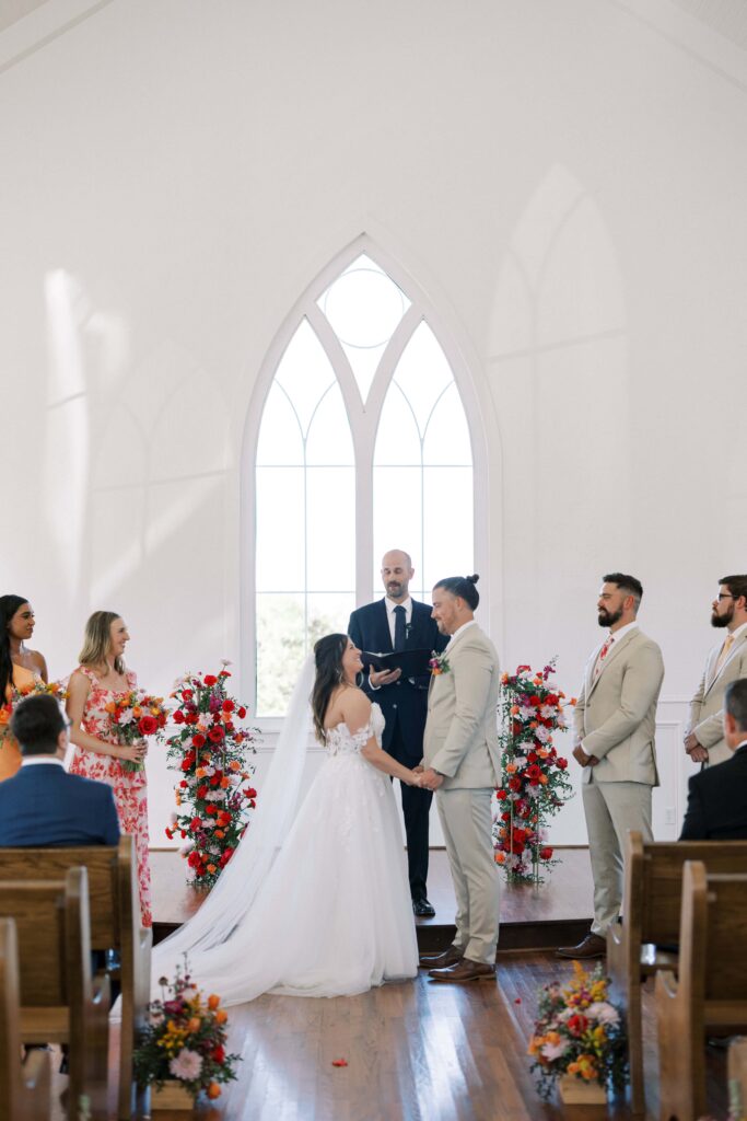 bride and groom at the altar holding hands at the chapel of The Springs Event Venue Weatherford