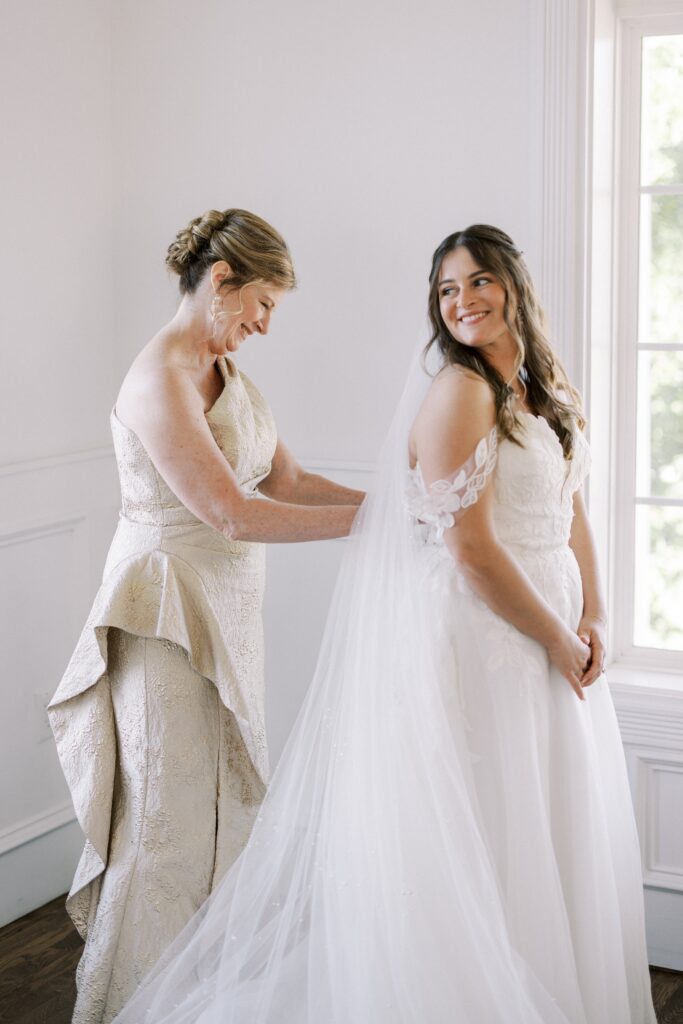 mom zipping up her daughter's wedding gown at The Springs Event Venue Weatherford