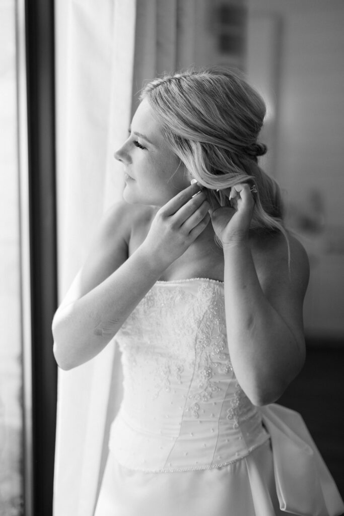 bride putting on her earring for her Wedding at Chandelier Farms