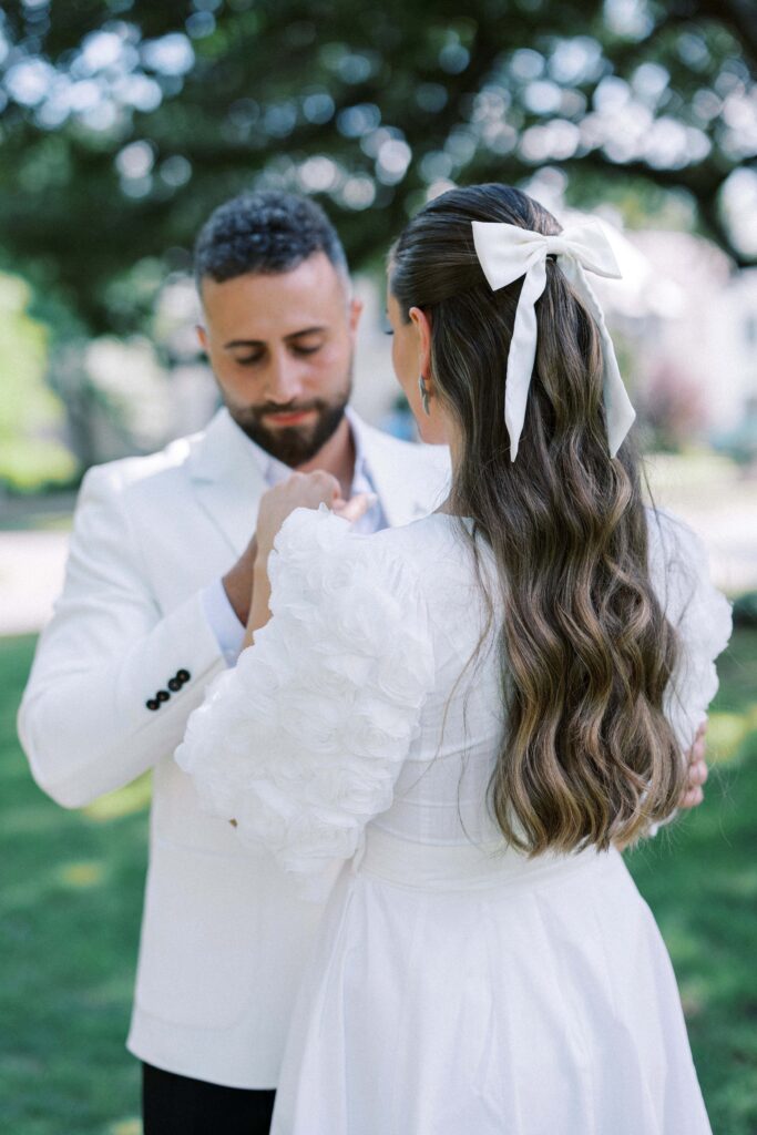 bride showing off the white bow in her hair during her Engagement Session at Flippen Park