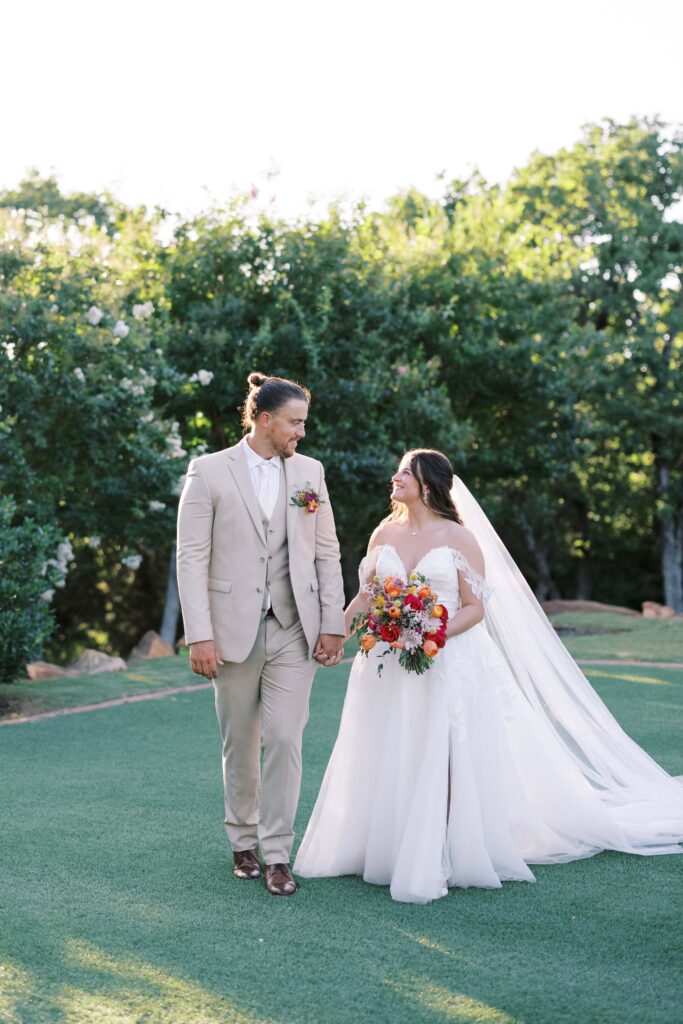 bride and groom in the garden at The Springs Event Venue Weatherford walking hand in hand