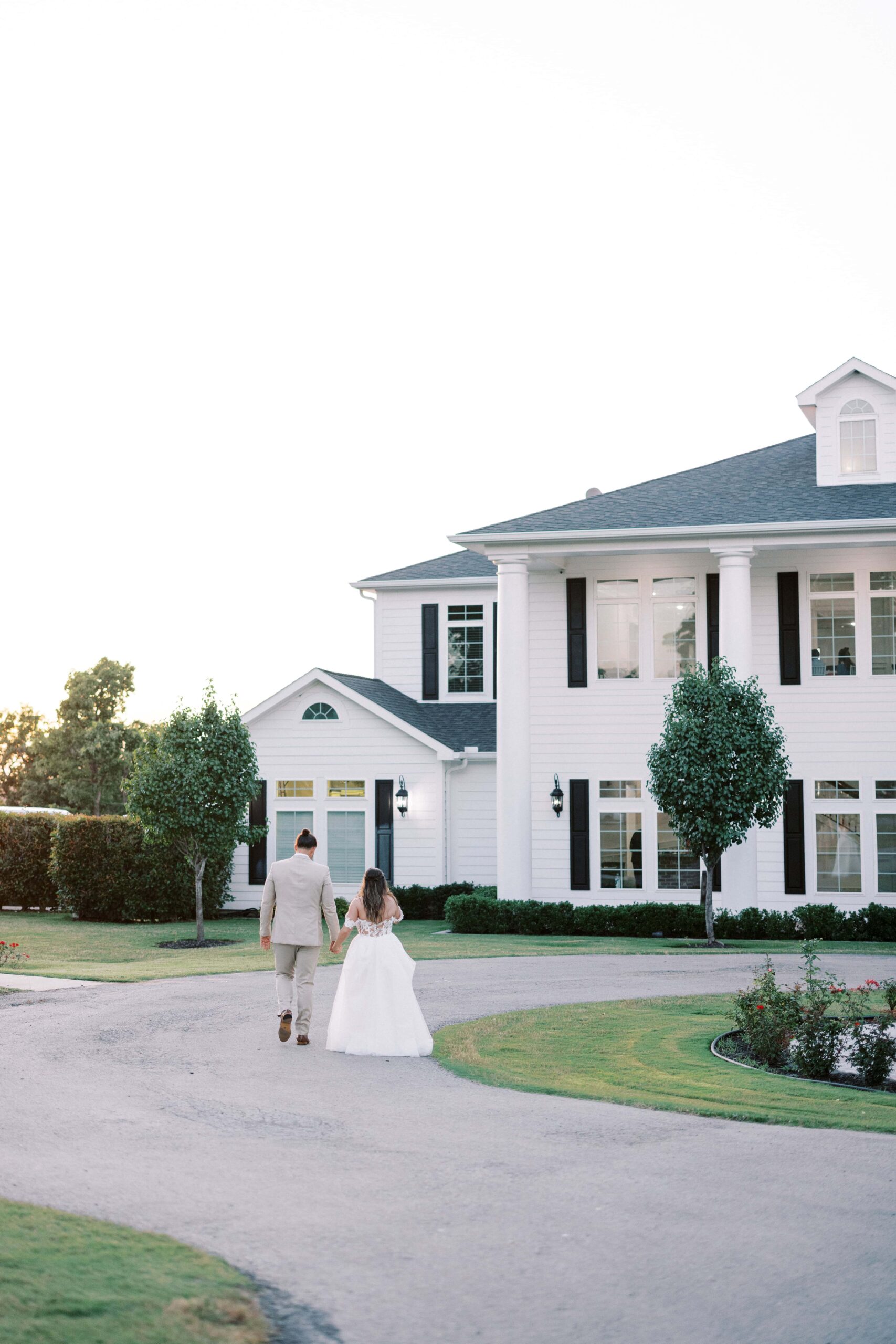 Bride and groom walking in front of the springs event venue weatherford