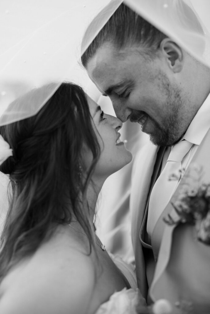 black and white of bride and groom nose to nose under the veil at The Springs Event Venue Weatherford 