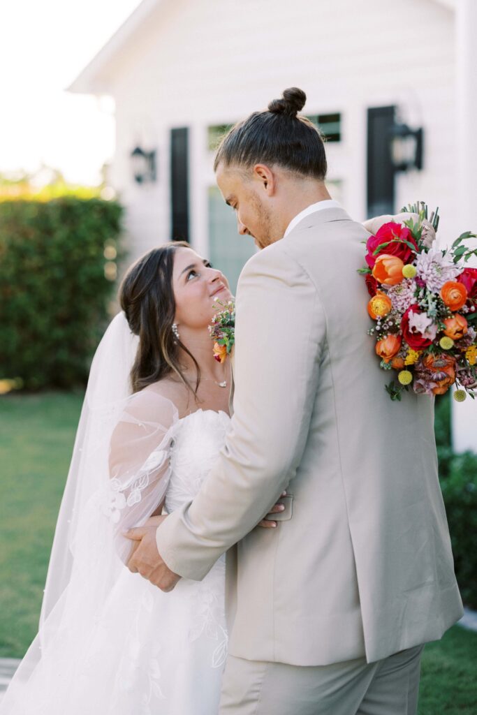 bride and groom looking at each other in font of The Springs Event Venue Weatherford