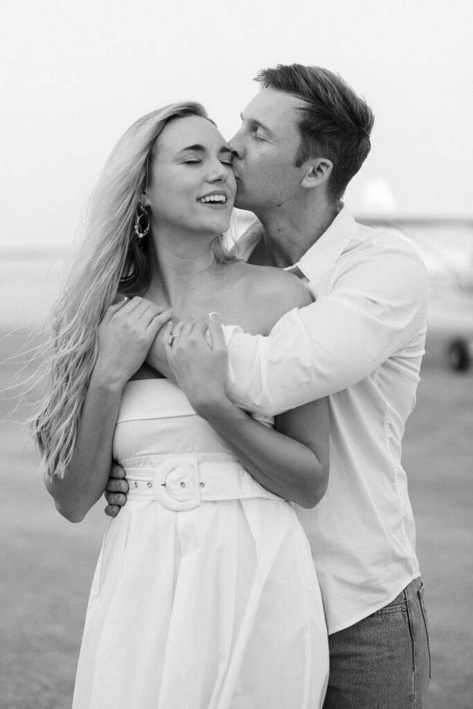 groom kissing the bride on the tarmac during their Airplane Engagement Session in Dallas-Fort Worth