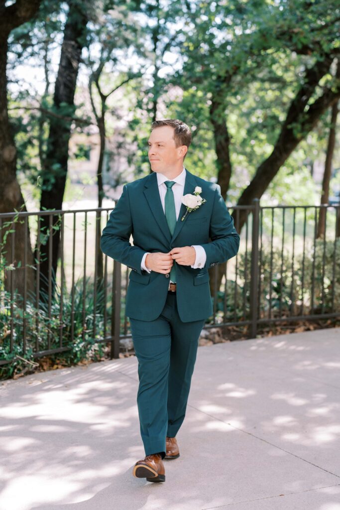 sean closing his emerald tuxedo jacket at his aristide mansfield wedding 