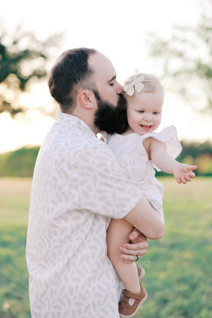 taylor kissing his baby on te cheek at their Sansom Park family session 