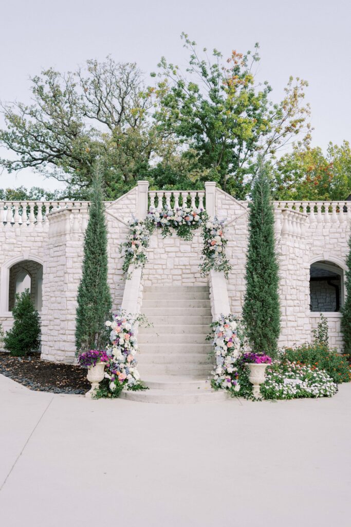 stairs adorned with colorful florals at this brighton abbey wedding