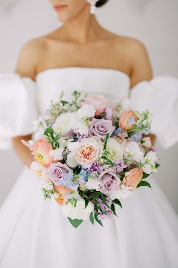 bride standing in the chapel showing off her bouquet at her brighton abbey wedding