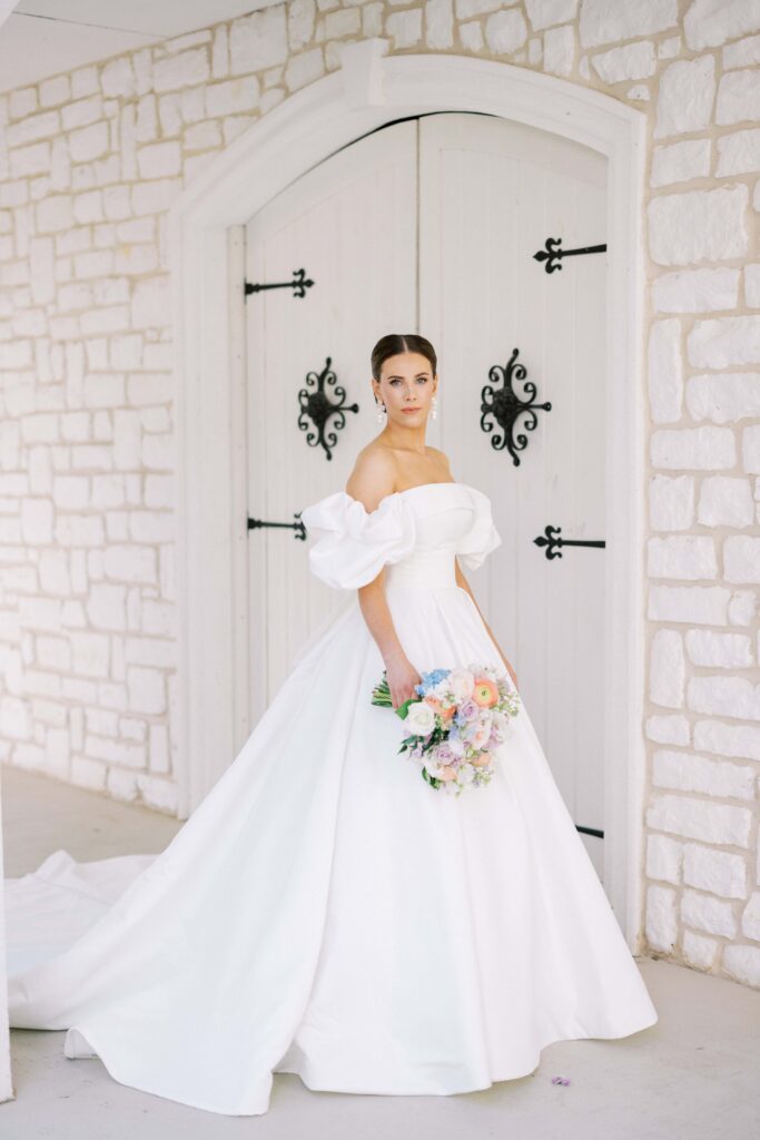 bride in the breezeway of her venue holding her bouquet at her brighton abbey wedding