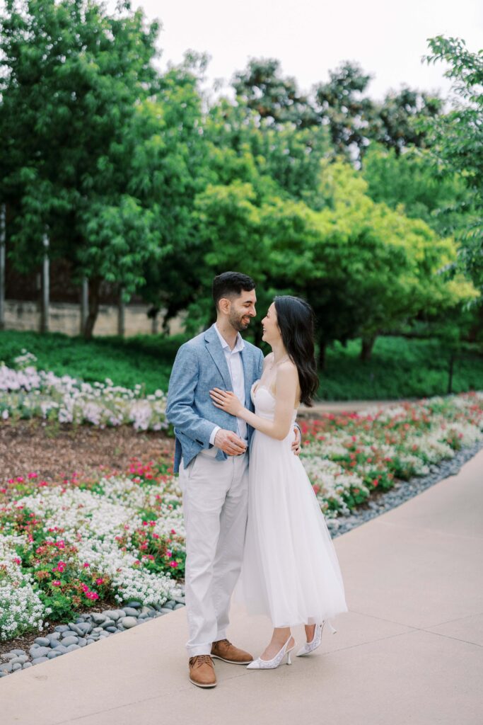 couple holding each other at their engagement photos at the Dallas Arboretum