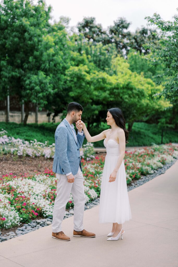 Alessandro kissing Rita's hand at their engagement photos at the Dallas Arboretum