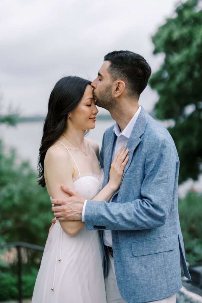 Alessandro kissing Rita on the forehead during their engagement photos at the Dallas Arboretum