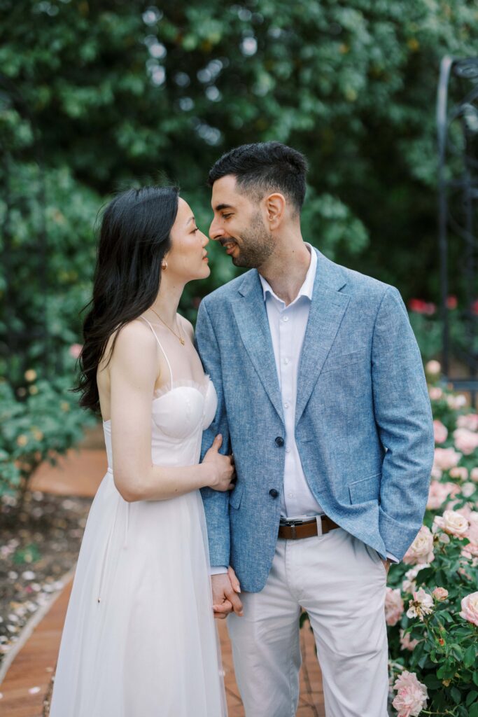Couple looking at each other for their engagement photos at the Dallas Arboretum