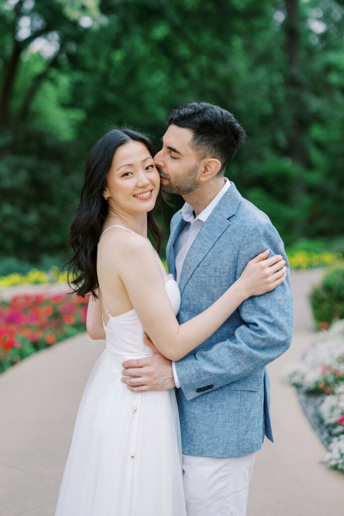 Alessandro kissing Rita for their engagement photos at the Dallas Arboretum