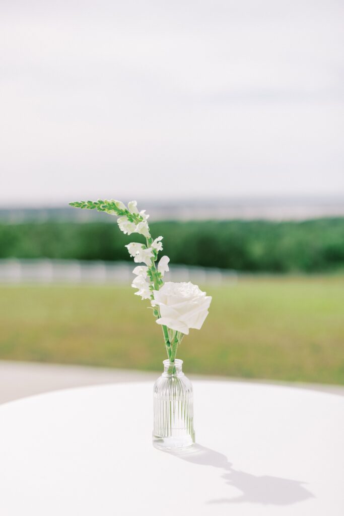 white flowers in a clear bud vase at this Lakeview Hills Wedding