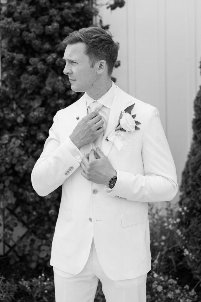 groom adjusting his tie at his Lakeview Hills Wedding