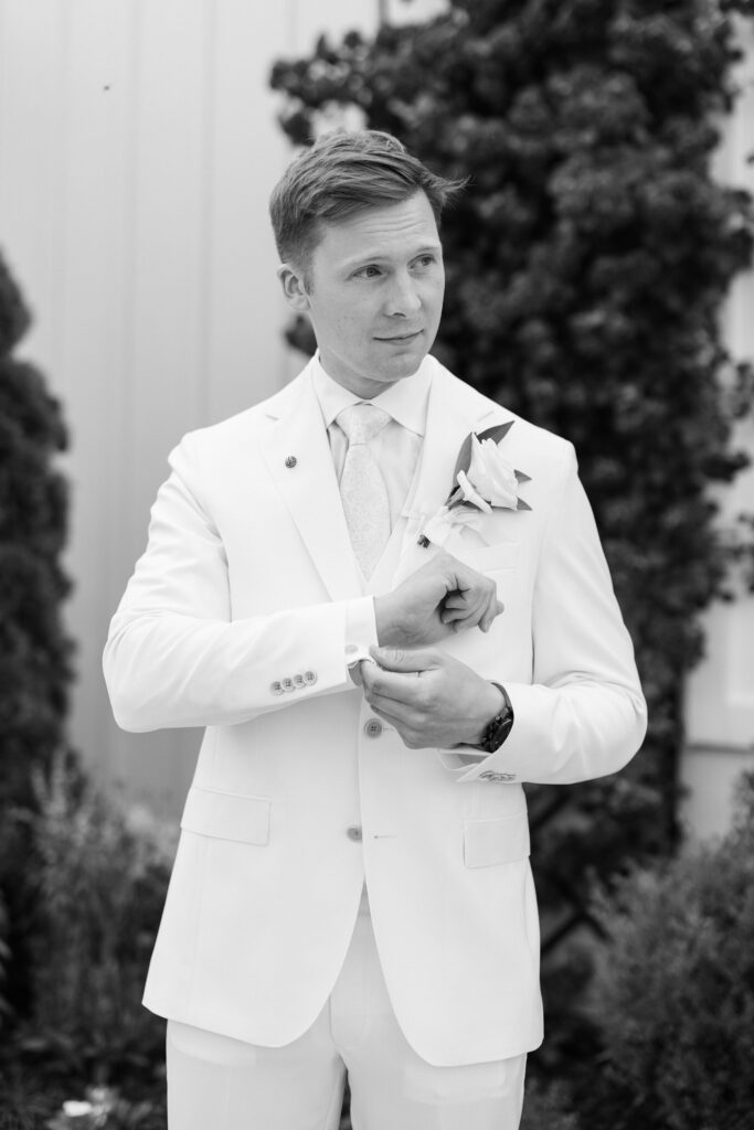 black and white of the groom in front of the venue for his Lakeview Hills Wedding