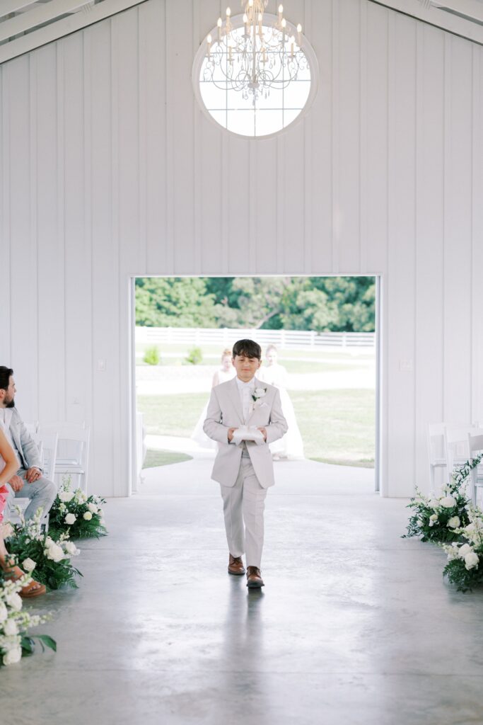 ring bearer walking down the aisle for this Lakeview Hills Wedding