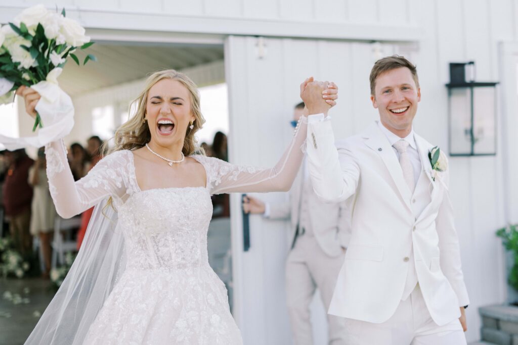 bride and groom cheering as newlyweds at their Lakeview Hills Wedding