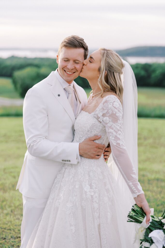 bride kissing the groom on the cheek at heir Lakeview Hills Wedding